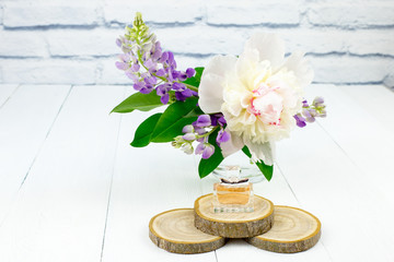perfume bottle with flowers on white wooden background