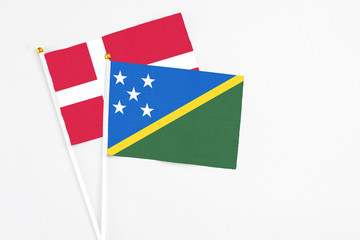 Solomon Islands and Denmark stick flags on white background. High quality fabric, miniature national flag. Peaceful global concept.White floor for copy space.