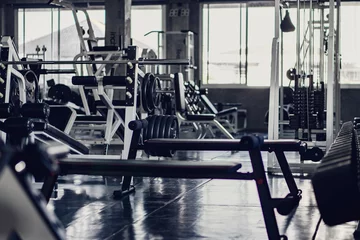 Fototapeten Innenhintergrund des Raumes im Fitnessstudio oder Fitnesscenter, komplett mit Bodybuilding-Ausrüstungen und -Maschinen ausgestattet © Mongkolchon