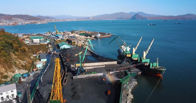 Coal port. Flying over a coal port in the small town of Nakhodka. Coal loading on a cargo ship in the sea coal port.