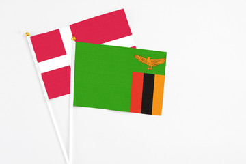 Zambia and Denmark stick flags on white background. High quality fabric, miniature national flag. Peaceful global concept.White floor for copy space.