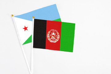 Afghanistan and Djibouti stick flags on white background. High quality fabric, miniature national...