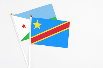 Congo and Djibouti stick flags on white background. High quality fabric, miniature national flag. Peaceful global concept.White floor for copy space.