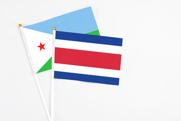 Costa Rica and Djibouti stick flags on white background. High quality fabric, miniature national flag. Peaceful global concept.White floor for copy space.