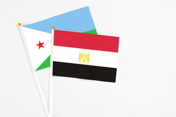 Egypt and Djibouti stick flags on white background. High quality fabric, miniature national flag. Peaceful global concept.White floor for copy space.