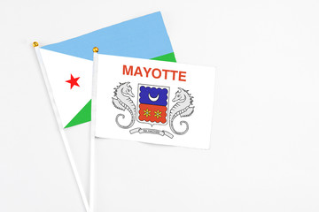 Mayotte and Djibouti stick flags on white background. High quality fabric, miniature national flag. Peaceful global concept.White floor for copy space.