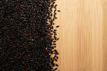 black rice layout on wooden table with text space