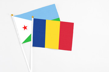 Romania and Djibouti stick flags on white background. High quality fabric, miniature national flag....