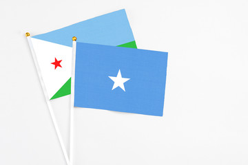 Somalia and Djibouti stick flags on white background. High quality fabric, miniature national flag. Peaceful global concept.White floor for copy space.