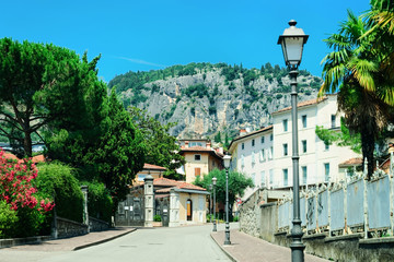 Landscape with road at Arco town on Garda Lake in Trentino in Italy. Rural scenery of countryside with palm trees in Trento region at Alps hills and mountains. Motorway with green nature.