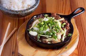 Flipino sisig in a cast iron skillet with rice