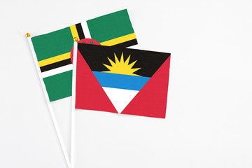 Antigua and Barbuda and Dominica stick flags on white background. High quality fabric, miniature national flag. Peaceful global concept.White floor for copy space.