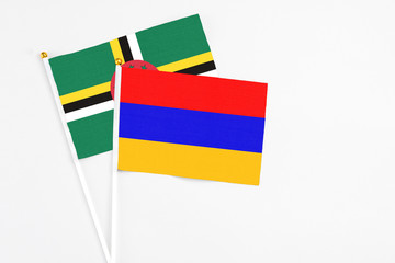 Armenia and Dominica stick flags on white background. High quality fabric, miniature national flag. Peaceful global concept.White floor for copy space.