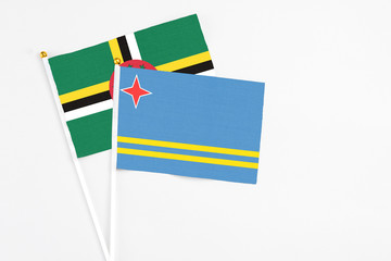 Aruba and Dominica stick flags on white background. High quality fabric, miniature national flag. Peaceful global concept.White floor for copy space.
