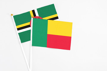 Benin and Dominica stick flags on white background. High quality fabric, miniature national flag....
