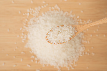 rice pile with wooden spoon on wooden table