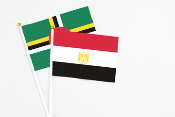 Egypt and Dominica stick flags on white background. High quality fabric, miniature national flag. Peaceful global concept.White floor for copy space.
