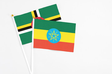 Ethiopia and Dominica stick flags on white background. High quality fabric, miniature national flag. Peaceful global concept.White floor for copy space.