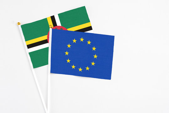 European Union and Dominica stick flags on white background. High quality fabric, miniature national flag. Peaceful global concept.White floor for copy space.