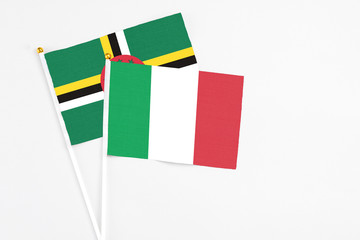 Italy and Dominica stick flags on white background. High quality fabric, miniature national flag. Peaceful global concept.White floor for copy space.