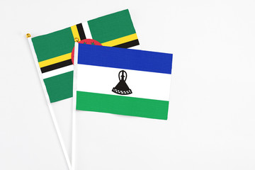 Lesotho and Dominica stick flags on white background. High quality fabric, miniature national flag. Peaceful global concept.White floor for copy space.