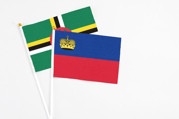 Liechtenstein and Dominica stick flags on white background. High quality fabric, miniature national flag. Peaceful global concept.White floor for copy space.