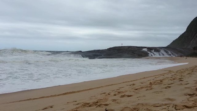 Rough sea. Strong waves crushing Pampo Rock. Itacoatiara Beach, Rio de Janeiro.