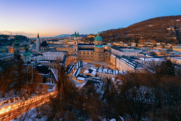 Panorama of Salzburg Cathedral with snow from Hohensalzburg castle in Austria in evening. Landscape and cityscape of Mozart city in Europe at winter. View of old Austrian town of Salzburgerland