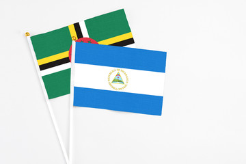 Nicaragua and Dominica stick flags on white background. High quality fabric, miniature national...