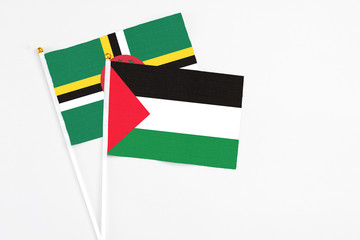 Palestine and Dominica stick flags on white background. High quality fabric, miniature national flag. Peaceful global concept.White floor for copy space.