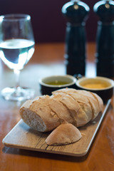 Handmade Bread Loaf and olive oil and Miso butter on a wooden platter