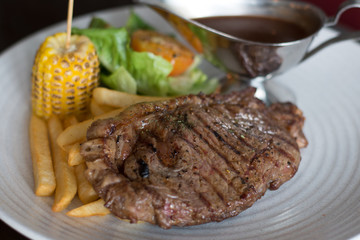 grilled sirloin with served with french fries and baked corn and black pepper sauce