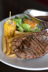 grilled sirloin with served with french fries and baked corn and black pepper sauce