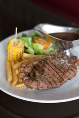 grilled sirloin with served with french fries and baked corn and black pepper sauce