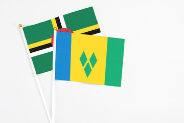 Saint Vincent And The Grenadines and Dominica stick flags on white background. High quality fabric,...