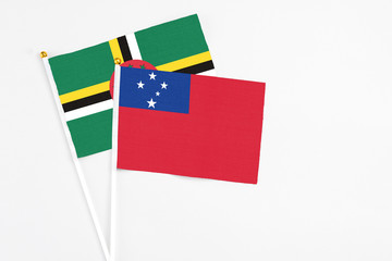 Samoa and Dominica stick flags on white background. High quality fabric, miniature national flag. Peaceful global concept.White floor for copy space.