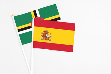 Spain and Dominica stick flags on white background. High quality fabric, miniature national flag. Peaceful global concept.White floor for copy space.