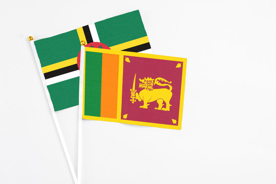 Sri Lanka and Dominica stick flags on white background. High quality fabric, miniature national flag. Peaceful global concept.White floor for copy space.