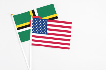United States and Dominica stick flags on white background. High quality fabric, miniature national flag. Peaceful global concept.White floor for copy space.