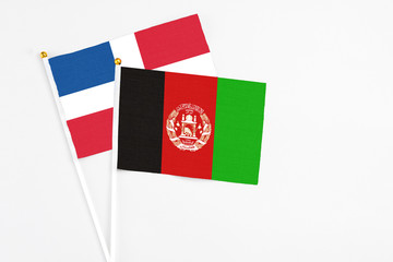 Afghanistan and Dominican Republic stick flags on white background. High quality fabric, miniature national flag. Peaceful global concept.White floor for copy space.