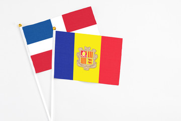 Andorra and Dominican Republic stick flags on white background. High quality fabric, miniature national flag. Peaceful global concept.White floor for copy space.