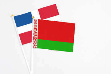 Belarus and Dominican Republic stick flags on white background. High quality fabric, miniature national flag. Peaceful global concept.White floor for copy space.
