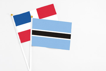 Botswana and Dominican Republic stick flags on white background. High quality fabric, miniature national flag. Peaceful global concept.White floor for copy space.