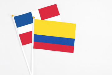 Colombia and Dominican Republic stick flags on white background. High quality fabric, miniature national flag. Peaceful global concept.White floor for copy space.