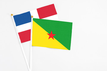 French Guiana and Dominican Republic stick flags on white background. High quality fabric, miniature national flag. Peaceful global concept.White floor for copy space.