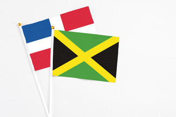 Jamaica and Dominican Republic stick flags on white background. High quality fabric, miniature national flag. Peaceful global concept.White floor for copy space.