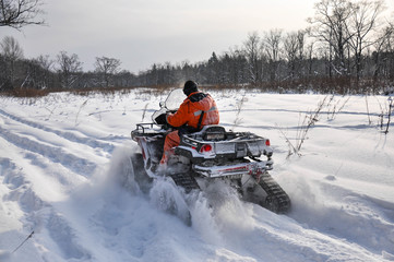 ATV on tracks ride on a snowy road in the taiga