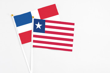Liberia and Dominican Republic stick flags on white background. High quality fabric, miniature national flag. Peaceful global concept.White floor for copy space.