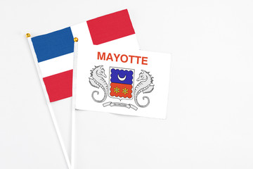 Mayotte and Dominican Republic stick flags on white background. High quality fabric, miniature national flag. Peaceful global concept.White floor for copy space.
