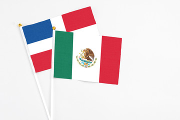 Mexico and Dominican Republic stick flags on white background. High quality fabric, miniature national flag. Peaceful global concept.White floor for copy space.
